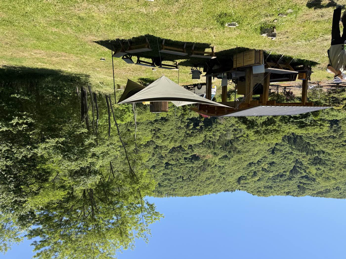 いくさか『創造の森』の風景。草地に建つ木造の東屋と、背後に広がる里山